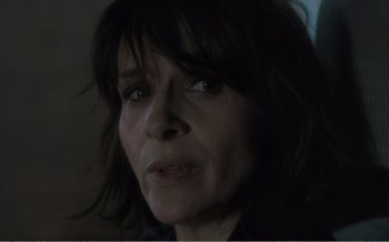 Movie still from “Let the Sunshine In” (2017), directed by Claire Denis – A woman's face in a dark room; Close Up shot, Over the shoulder angle
