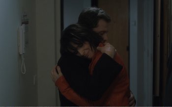 Movie still from “Let the Sunshine In” (2017), directed by Claire Denis – A man and a woman hugging in a dark room; Medium shot, High angle