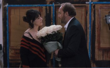 Movie still from “Let the Sunshine In” (2017), directed by Claire Denis – A man and a woman holding a bouquet of roses; Medium shot, Over the shoulder angle