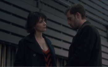 Movie still from “Let the Sunshine In” (2017), directed by Claire Denis – A man and a woman standing next to each other; Medium shot, Over the shoulder angle