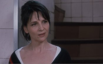 Movie still from “Let the Sunshine In” (2017), directed by Claire Denis – A person wearing a black and white shirt; Close Up shot, Over the shoulder angle