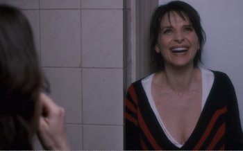 Movie still from “Let the Sunshine In” (2017), directed by Claire Denis – A woman is taking a picture of herself in the mirror; Medium shot, Over the shoulder angle