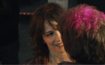 Movie still from “Let the Sunshine In” (2017), directed by Claire Denis – A woman smiles at another woman with pink hair; Close Up shot, Over the shoulder angle