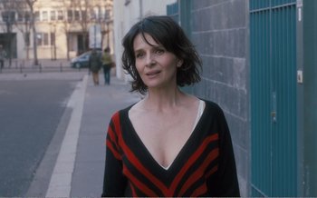 Movie still from “Let the Sunshine In” (2017), directed by Claire Denis – A woman standing on the side of the street; Close Up shot, Over the shoulder angle