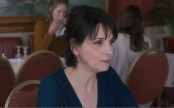 Movie still from “Let the Sunshine In” (2017), directed by Claire Denis – A person sitting in a room; Close Up shot, Over the shoulder angle