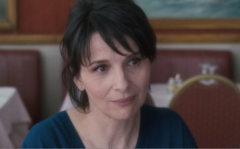 Movie still from “Let the Sunshine In” (2017), directed by Claire Denis – A person sitting at a table; Close Up shot, Over the shoulder angle