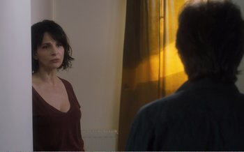 Movie still from “Let the Sunshine In” (2017), directed by Claire Denis – A woman standing in front of a bathroom mirror; Medium shot, Over the shoulder angle
