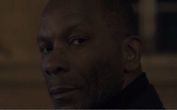 Movie still from “Let the Sunshine In” (2017), directed by Claire Denis – A man's face in the dark; Close Up shot, Low angle