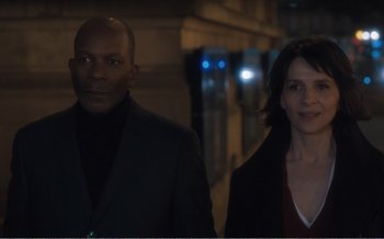 Movie still from “Let the Sunshine In” (2017), directed by Claire Denis – A man and a woman standing next to each other; Medium shot, Low angle