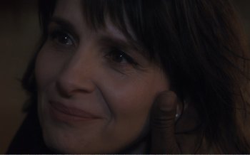 Movie still from “Let the Sunshine In” (2017), directed by Claire Denis – A woman's face with her hand touching her ear; Extreme Close Up shot, Over the shoulder angle