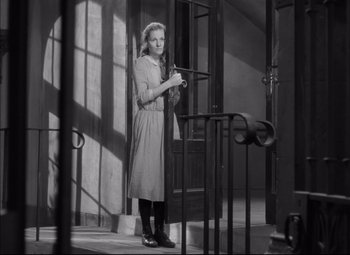 Movie still from “Letter from an Unknown Woman” (1948), directed by Max Ophüls – A woman in a dress standing in a room; Medium shot, Low angle