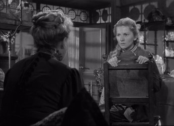 Movie still from “Letter from an Unknown Woman” (1948), directed by Max Ophüls – A woman sitting in a chair in front of another woman; Medium shot, Over the shoulder angle