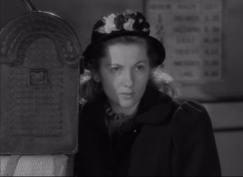 Movie still from “Letter from an Unknown Woman” (1948), directed by Max Ophüls – A young woman wearing a hat standing in front of a mailbox; Close Up shot, Low angle