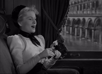 Movie still from “Letter from an Unknown Woman” (1948), directed by Max Ophüls – A black and white photo of a woman on a train; Medium shot, Low angle