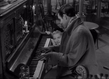 Movie still from “Letter from an Unknown Woman” (1948), directed by Max Ophüls – A man and a little girl are playing the piano; Medium shot, High angle