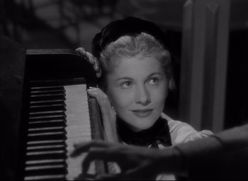 Movie still from “Letter from an Unknown Woman” (1948), directed by Max Ophüls – An old black and white photo of a woman leaning on a piano; Close Up shot, High angle