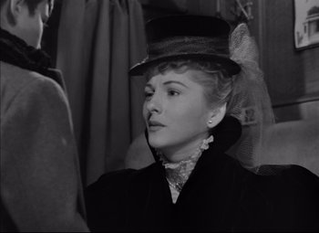 Movie still from “Letter from an Unknown Woman” (1948), directed by Max Ophüls – A woman wearing a black hat and a black coat; Close Up shot, Over the shoulder angle