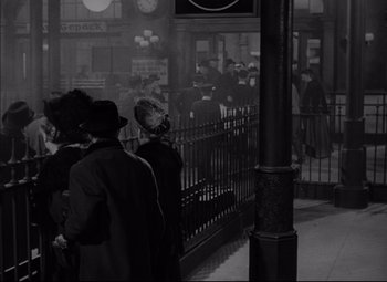 Movie still from “Letter from an Unknown Woman” (1948), directed by Max Ophüls – A black and white photo of people waiting at a train station; Wide shot, High angle