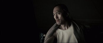 Movie still from “Letters from Iwo Jima” (2006), directed by Clint Eastwood – A man holding a towel over his shoulder looking to his left; Close Up shot, Low angle