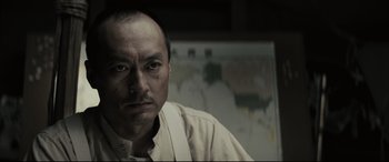 Movie still from “Letters from Iwo Jima” (2006), directed by Clint Eastwood – A person wearing a white shirt; Close Up shot, Low angle