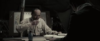Movie still from “Letters from Iwo Jima” (2006), directed by Clint Eastwood – A man sitting at a dinner table eating a bowl of soup; Medium shot, Over the shoulder angle