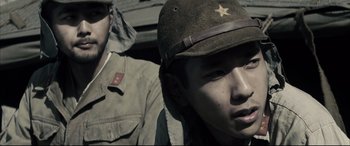 Movie still from “Letters from Iwo Jima” (2006), directed by Clint Eastwood – A man in a military uniform and a man with a hat; Close Up shot, Over the shoulder angle