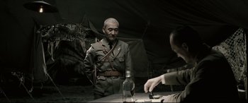 Movie still from “Letters from Iwo Jima” (2006), directed by Clint Eastwood – A man in a military uniform standing next to a table; Medium shot, Over the shoulder angle