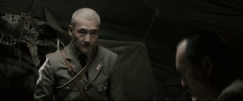 Movie still from “Letters from Iwo Jima” (2006), directed by Clint Eastwood – An older man in a uniform standing under an umbrella; Close Up shot, Low angle