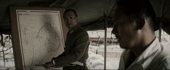 Movie still from “Letters from Iwo Jima” (2006), directed by Clint Eastwood – A man in a military uniform standing in front of a map; Close Up shot, High angle