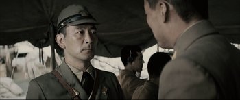 Movie still from “Letters from Iwo Jima” (2006), directed by Clint Eastwood – A man in a military uniform is talking to another man; Close Up shot, Over the shoulder angle