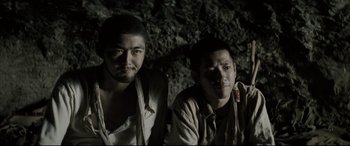 Movie still from “Letters from Iwo Jima” (2006), directed by Clint Eastwood – A couple of men sitting next to each other in a cave; Close Up shot, Low angle