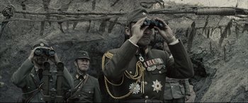 Movie still from “Letters from Iwo Jima” (2006), directed by Clint Eastwood – A man in military uniform looking through binoculars; Medium shot, Low angle