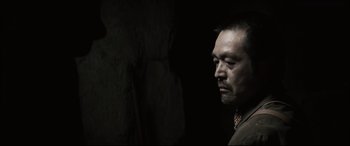 Movie still from “Letters from Iwo Jima” (2006), directed by Clint Eastwood – A man in a dark room looking down at the ground; Close Up shot, Low angle