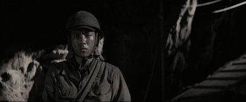 Movie still from “Letters from Iwo Jima” (2006), directed by Clint Eastwood – A man in a military uniform standing next to a tree; Close Up shot, Low angle