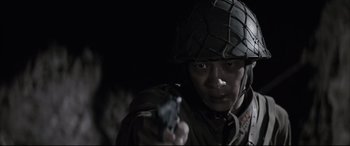 Movie still from “Letters from Iwo Jima” (2006), directed by Clint Eastwood – A man wearing a helmet and holding a gun in his hand; Close Up shot, Low angle