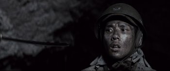 Movie still from “Letters from Iwo Jima” (2006), directed by Clint Eastwood – A man in a military uniform with a helmet on his head; Close Up shot, High angle