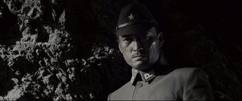 Movie still from “Letters from Iwo Jima” (2006), directed by Clint Eastwood – A man wearing a uniform and a hat in the dark; Close Up shot, Low angle