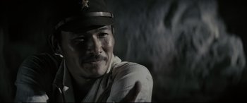 Movie still from “Letters from Iwo Jima” (2006), directed by Clint Eastwood – A man wearing a hat is smiling for the camera; Close Up shot, Low angle