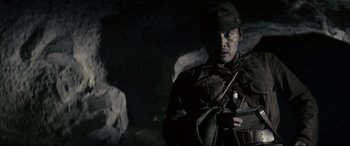 Movie still from “Letters from Iwo Jima” (2006), directed by Clint Eastwood – A man in a military uniform is holding a gun; Medium shot, Low angle