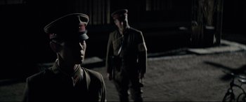 Movie still from “Letters from Iwo Jima” (2006), directed by Clint Eastwood – Two men dressed in military uniforms standing next to each other in the dark; Close Up shot, Low angle