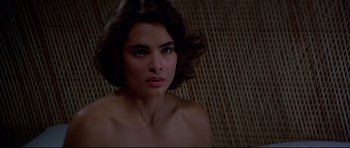 Movie still from “Licence to Kill” (1989), directed by John Glen – A beautiful young woman with a bare chest; Close Up shot, Low angle