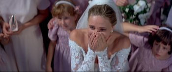 Movie still from “Licence to Kill” (1989), directed by John Glen – A woman in a wedding dress covering her mouth; Close Up shot, Over the shoulder angle