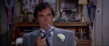 Movie still from “Licence to Kill” (1989), directed by John Glen – A person wearing a suit smoking a cigarette; Close Up shot, Over the shoulder angle