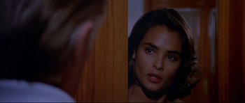 Movie still from “Licence to Kill” (1989), directed by John Glen – A woman looking into a mirror while standing next to a man; Close Up shot, Over the shoulder angle