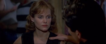 Movie still from “Licence to Kill” (1989), directed by John Glen – A woman is looking at a man with his hand on her shoulder; Close Up shot, Over the shoulder angle