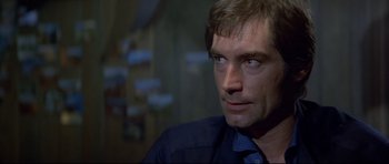 Movie still from “Licence to Kill” (1989), directed by John Glen – A person looking at the camera; Close Up shot, Over the shoulder angle