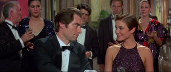 Movie still from “Licence to Kill” (1989), directed by John Glen – A man and a woman in formal wear at a party; Medium shot, Over the shoulder angle