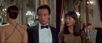 Movie still from “Licence to Kill” (1989), directed by John Glen – A man and a woman standing next to each other in formal wear; Medium shot, Low angle