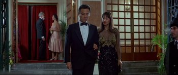 Movie still from “Licence to Kill” (1989), directed by John Glen – A man and a woman are walking together in formal wear; Medium shot, Low angle