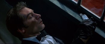 Movie still from “Licence to Kill” (1989), directed by John Glen – A person wearing a suit and bow tie; Close Up shot, High angle